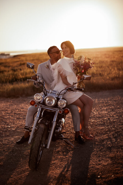 A cool wedding couple on a motorbike at sunset, from The Ferry House wedding venue in Kent