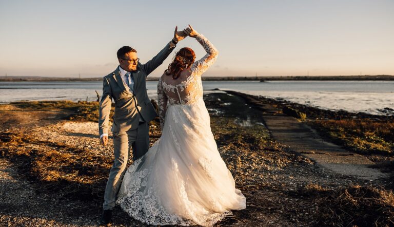 A wedding couple dance by the waterside during a spring wedding in the Kent countryside