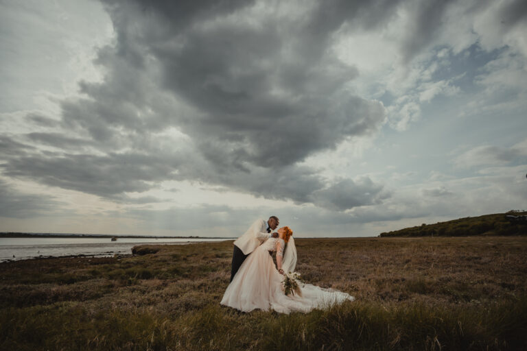 A wedding couple beside the Swale estuary wetlands in Kent