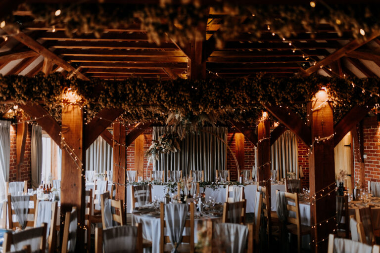 A stunning wedding breakfast set up at The Ferry House barn wedding venue in Kent