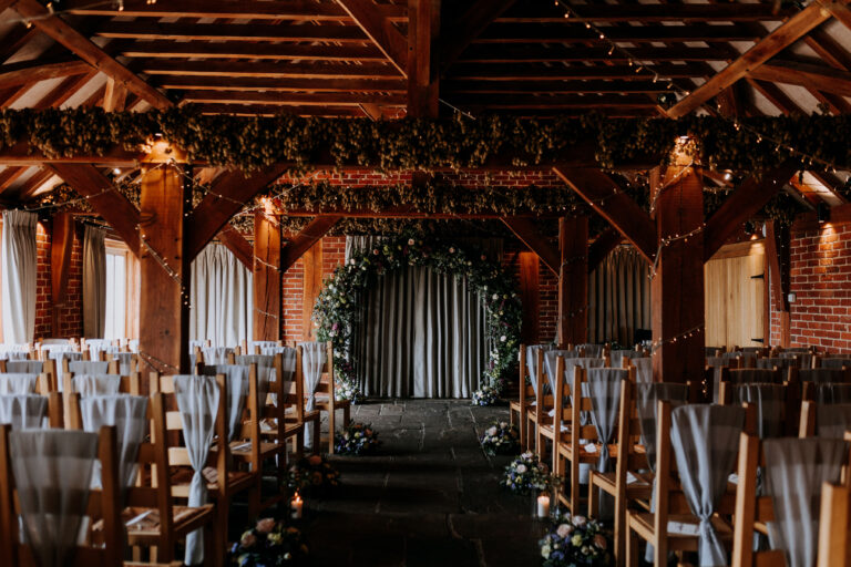 A beautiful foliage arch in the oak wedding barn of The Ferry House in Kent