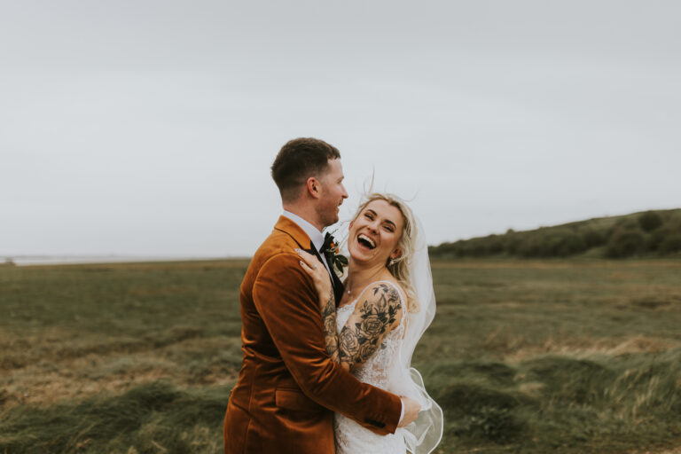 A bride and groom along the estuary of Kent wedding venue, The Ferry House.