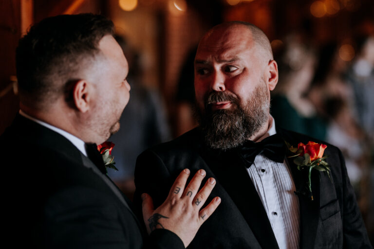 A best man comforting the groom during his wedding ceremony at The Ferry House in Kent. Captured by Chris Blackledge.