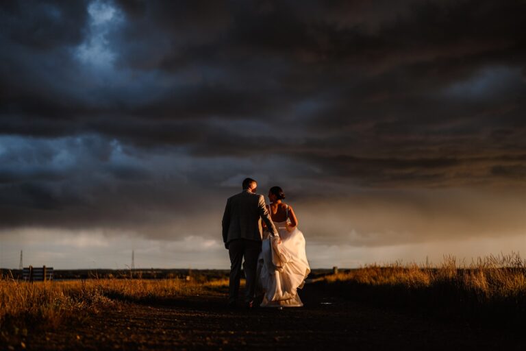 A wedding couple at The Ferry House in Kent looking at the swale estuary at sunset.