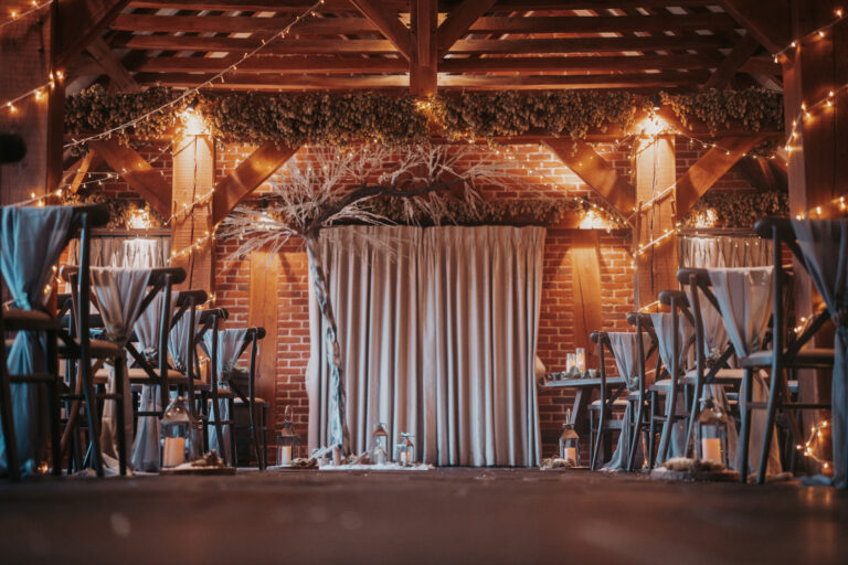 The Ferry House wedding venue in Kent styled for a barn wedding ceremony, with ornate white tree at the end of the aisle