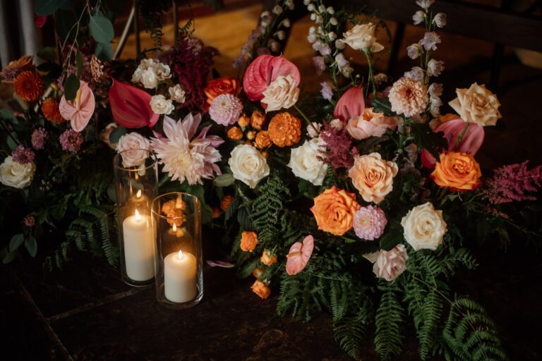 Beautiful colourful wedding flowers and candle jars